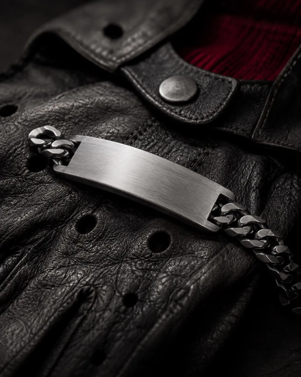 Graviertes Edelstahl-Armband auf einem Vintage-Rennhandschuh
