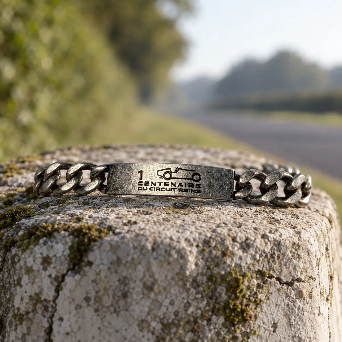1 CENTENAIRE DU CIRCUIT REIMS – Armband auf einem verwitterten Kilometerstein am Streckenrand, Gestaltungsentwurf